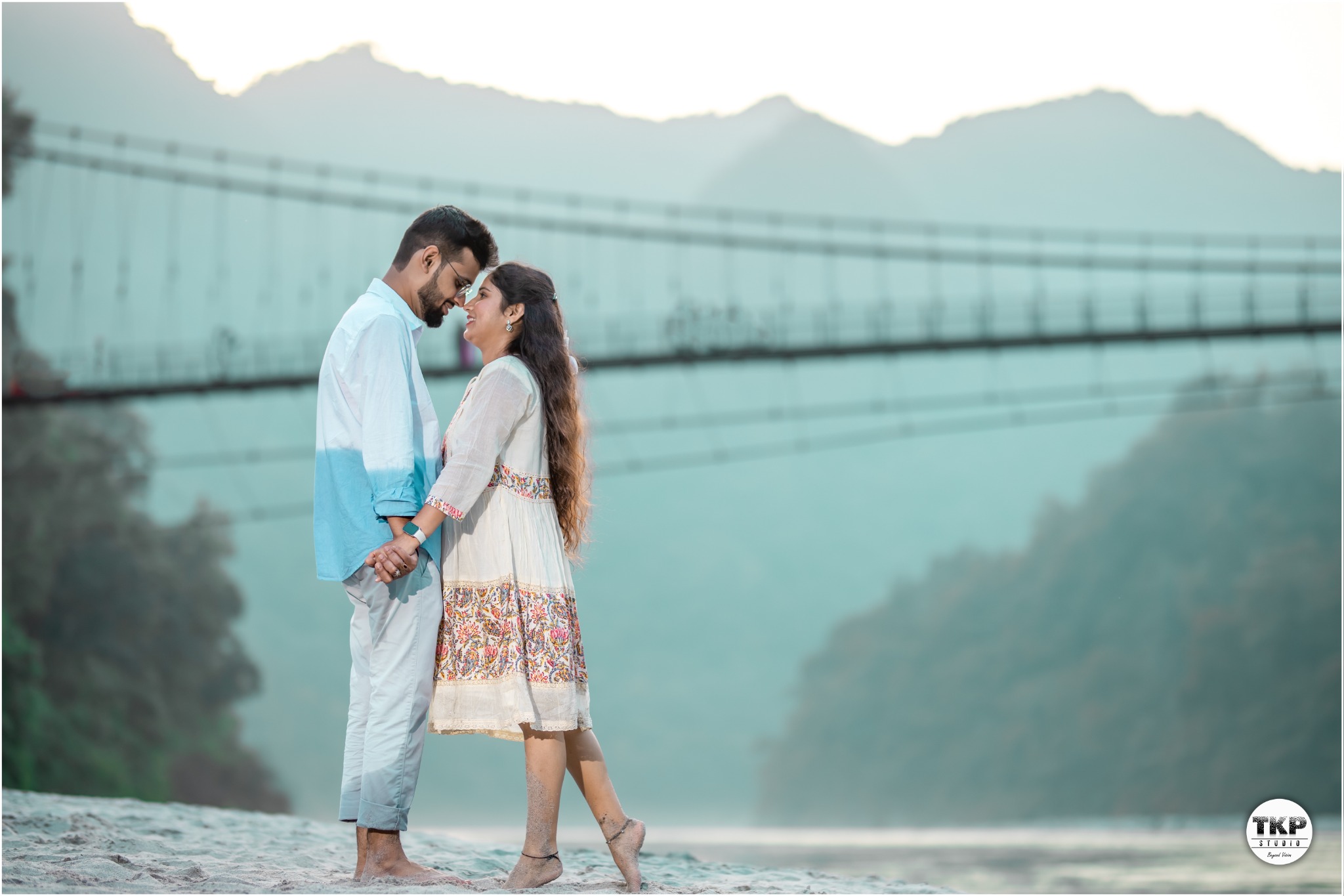 Couple in white outfits by the mountains
